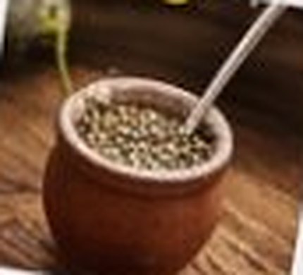 Mate de calabaza con yerba y bombilla sobre una mesa de madera